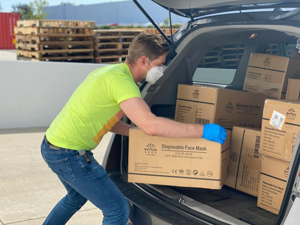 Person loading boxes of face masks.