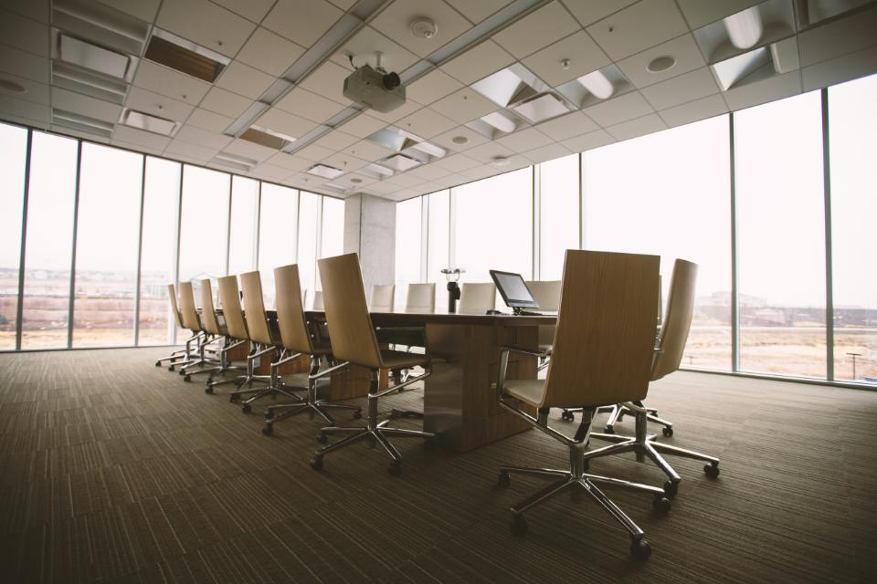 conference room with a long table, chairs, and a projector